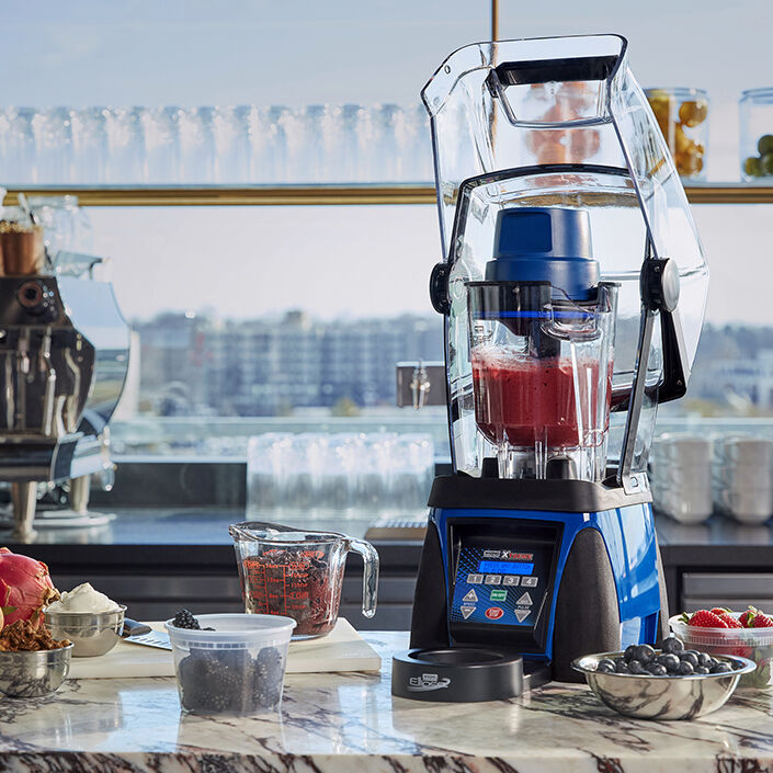 blender sitting on counter with smoothie bowl ingredients around it